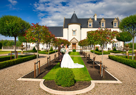 Bride and groom standing in venue gardens